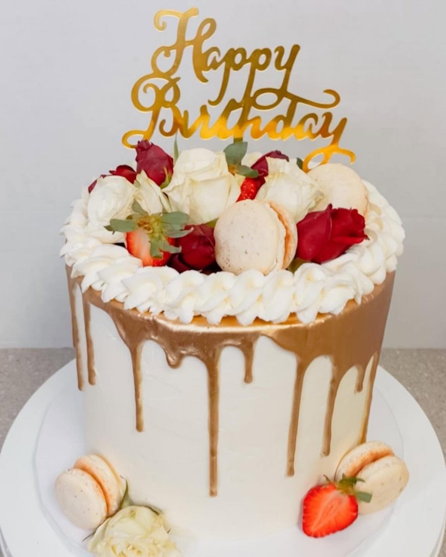 Cakes & Bakes's own photograph: a caramel drip cake topped with roses, strawberries and macarons.