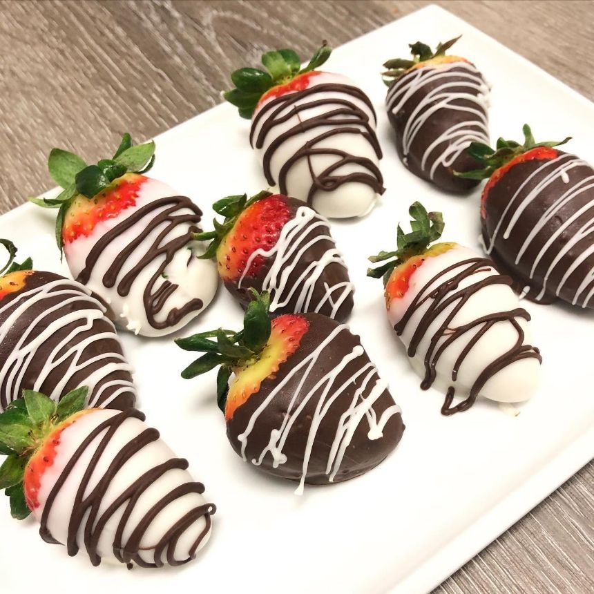 Cakes & Bakes's own photograph: strawberries dipped in dark and white chocolate on a white plate.
