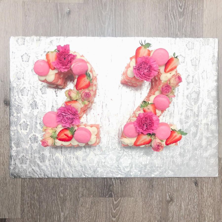 Cakes & Bakes's own photograph: the number twenty two shaped in cake and dressed with macarons, strawberries and flowers.